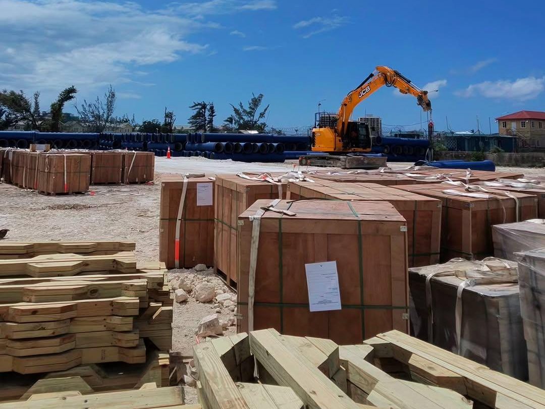 Organized material staging yard with crated supplies, lumber, and equipment
